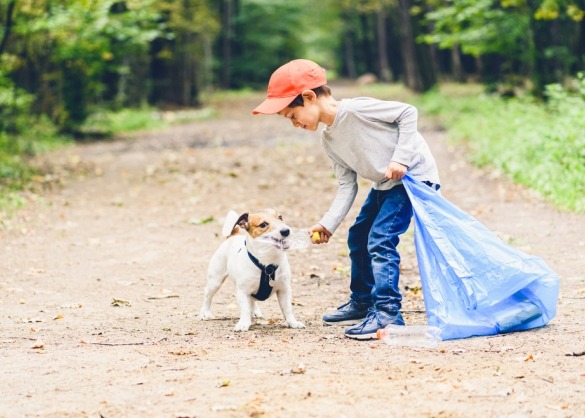 Kind en hond rapen vuilnis op 
