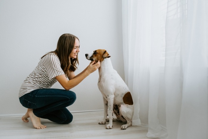 Vrouw knielt neer naast hond