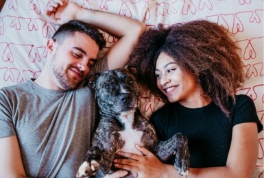 Koppel ligt met hond in bed