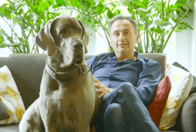 Faroek zit in de zetel met zijn Duitse dog Norah