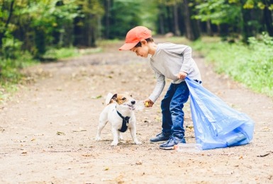 Kind en hond rapen vuilnis op 